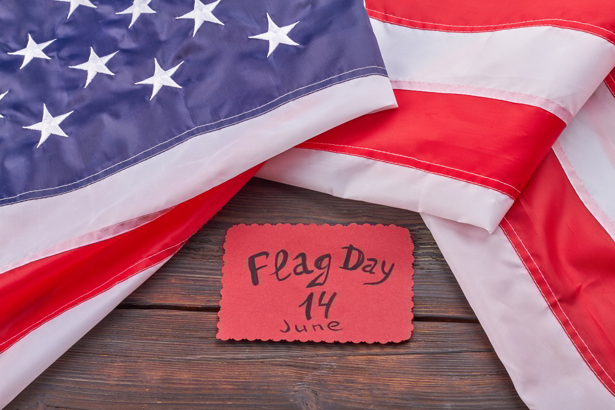 The United States flag day 14 june on wooden desk.