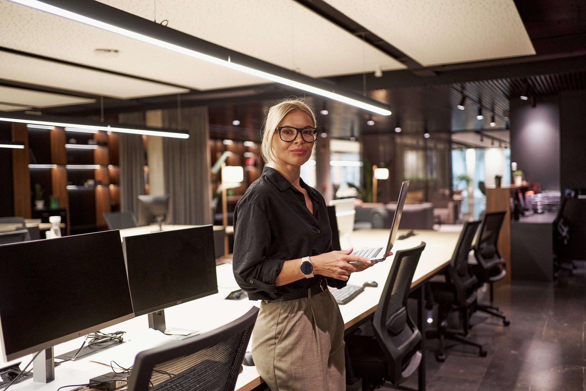 This image portrays a contemporary office environment showcasing a professional woman at work