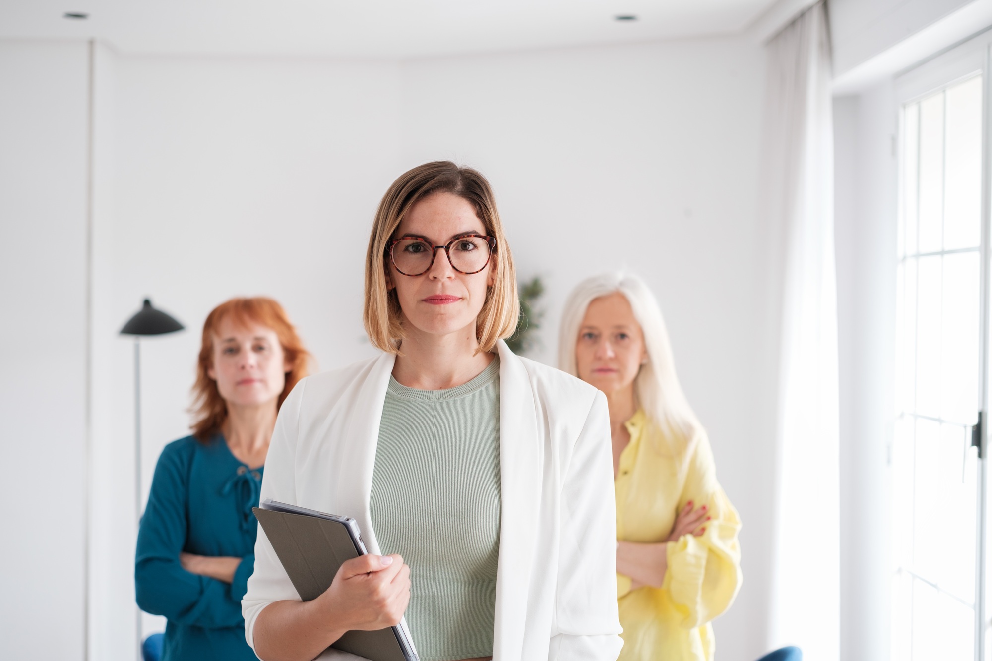 Three businesswomen together in the management team photos in the office. Concept: business