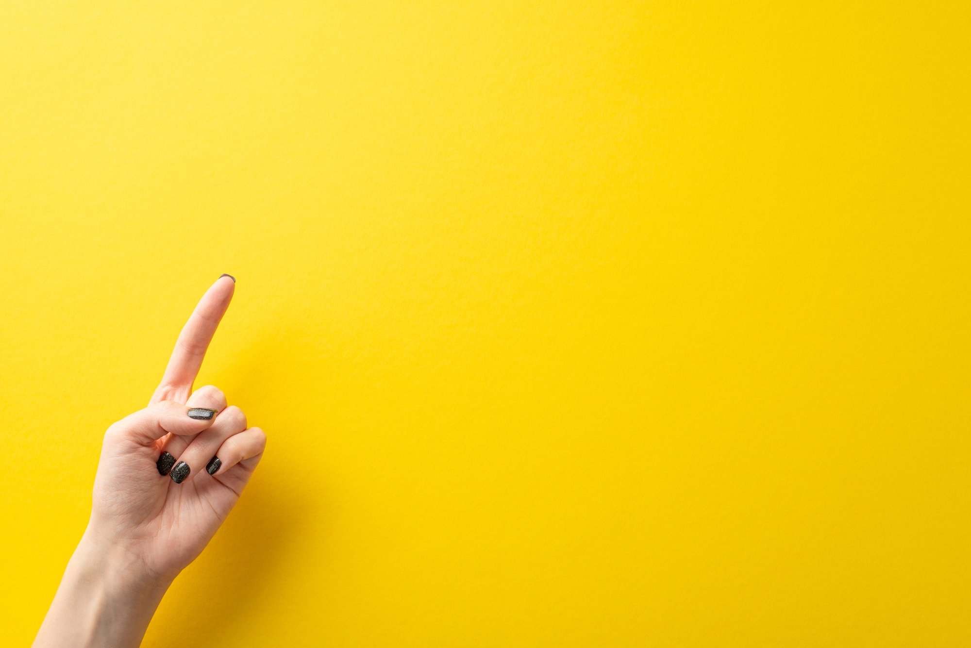 Top-down image featuring the hand of a young woman, her black manicure contrasting elegantly