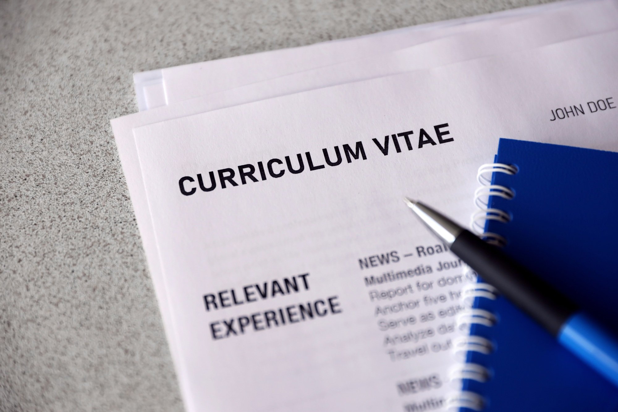 Top view of stack of office documents including resume and cv forms