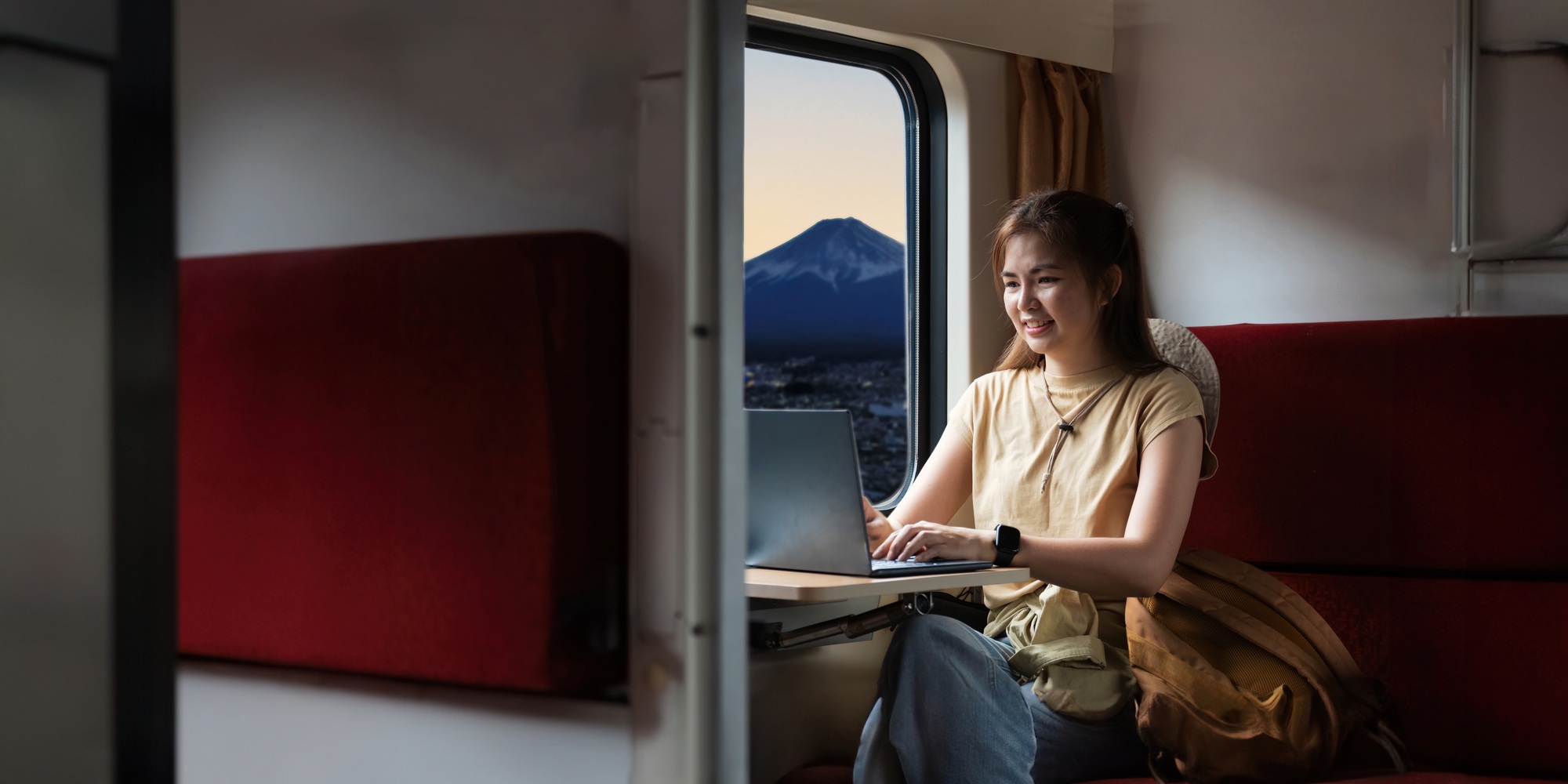 Traveler young woman travel in train. Remotely work on laptop during sitting inside . travelling