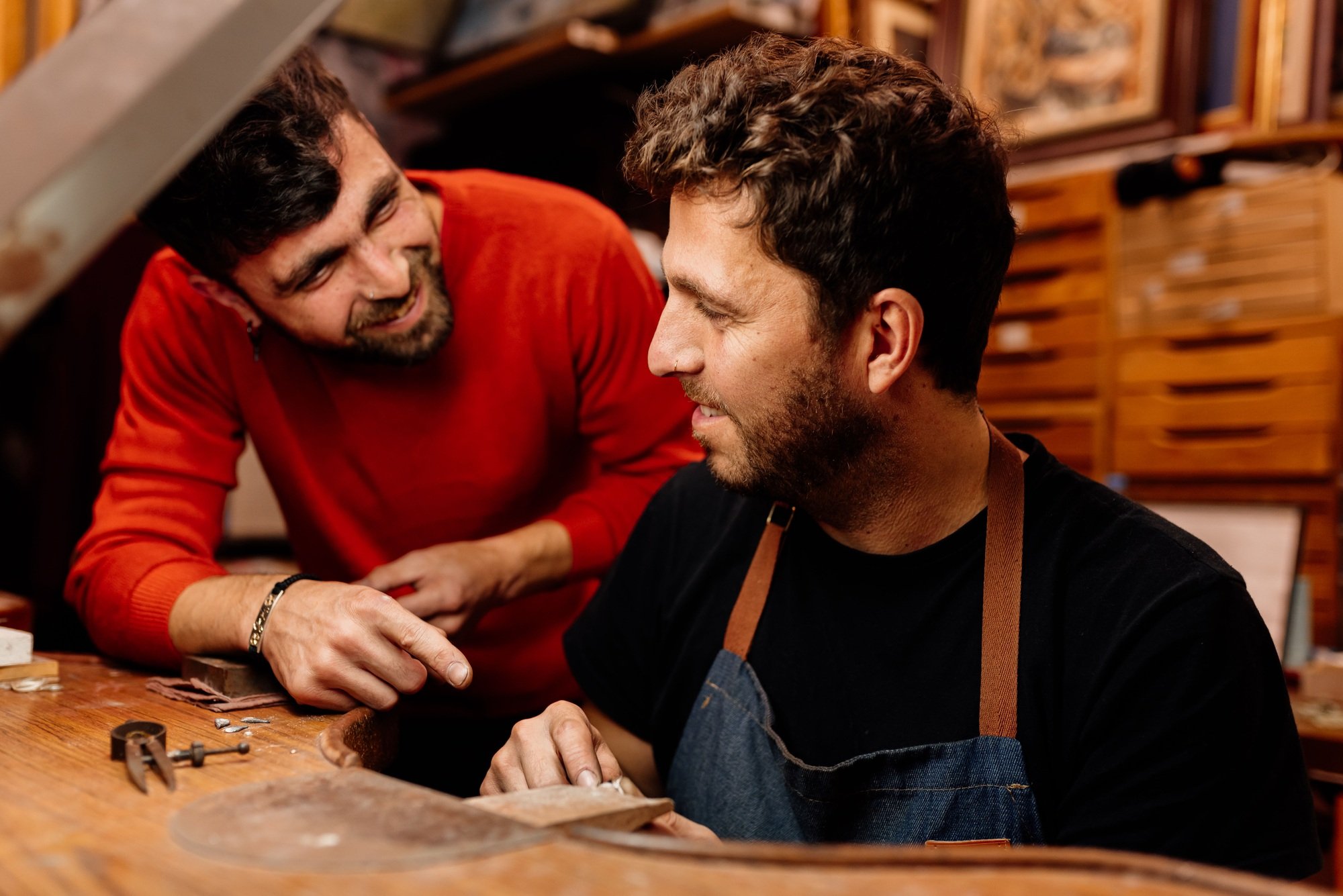 Two men work together in their small jewelry business.