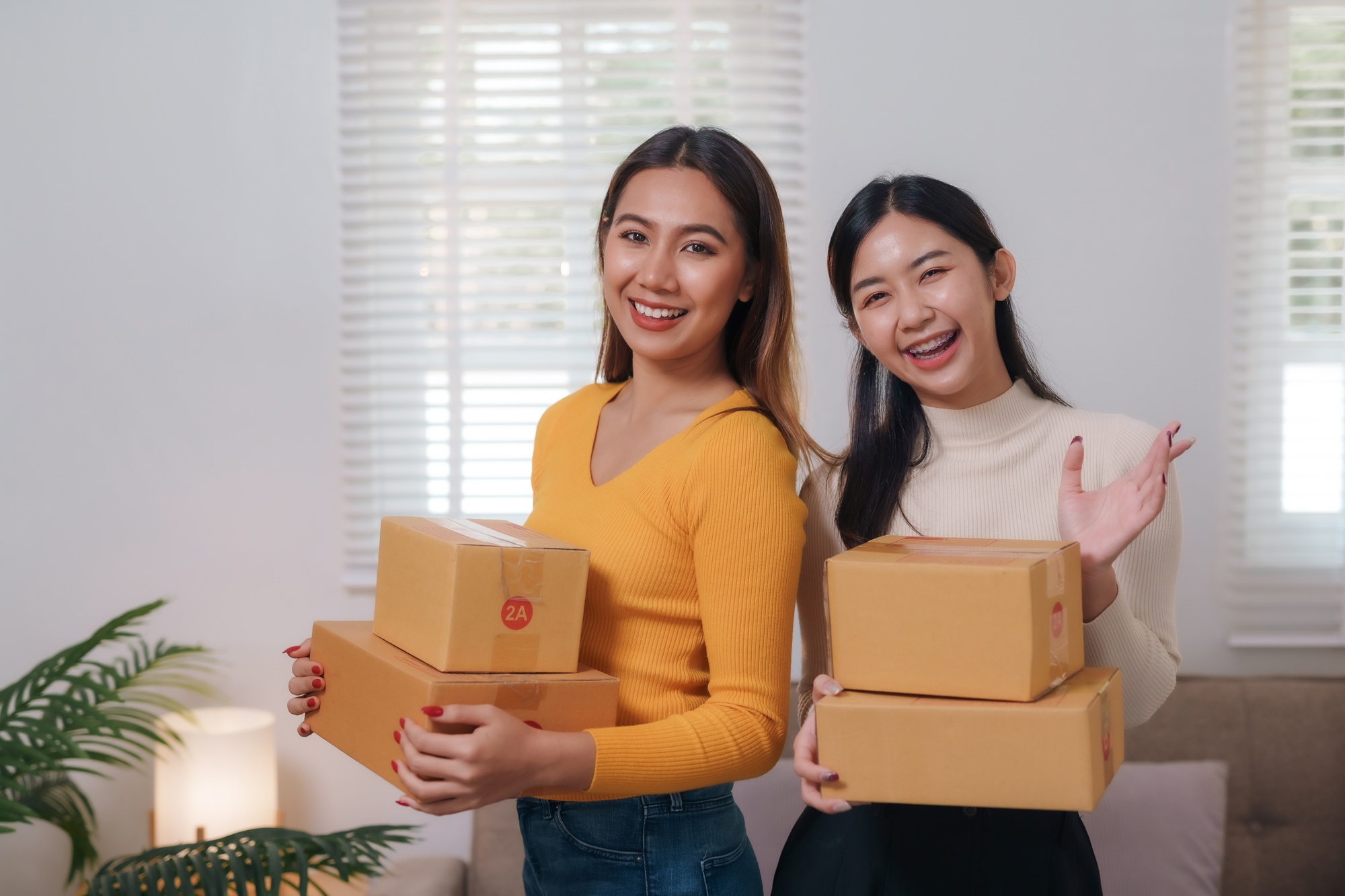 Two online influencers holding parcels for product promotion.
