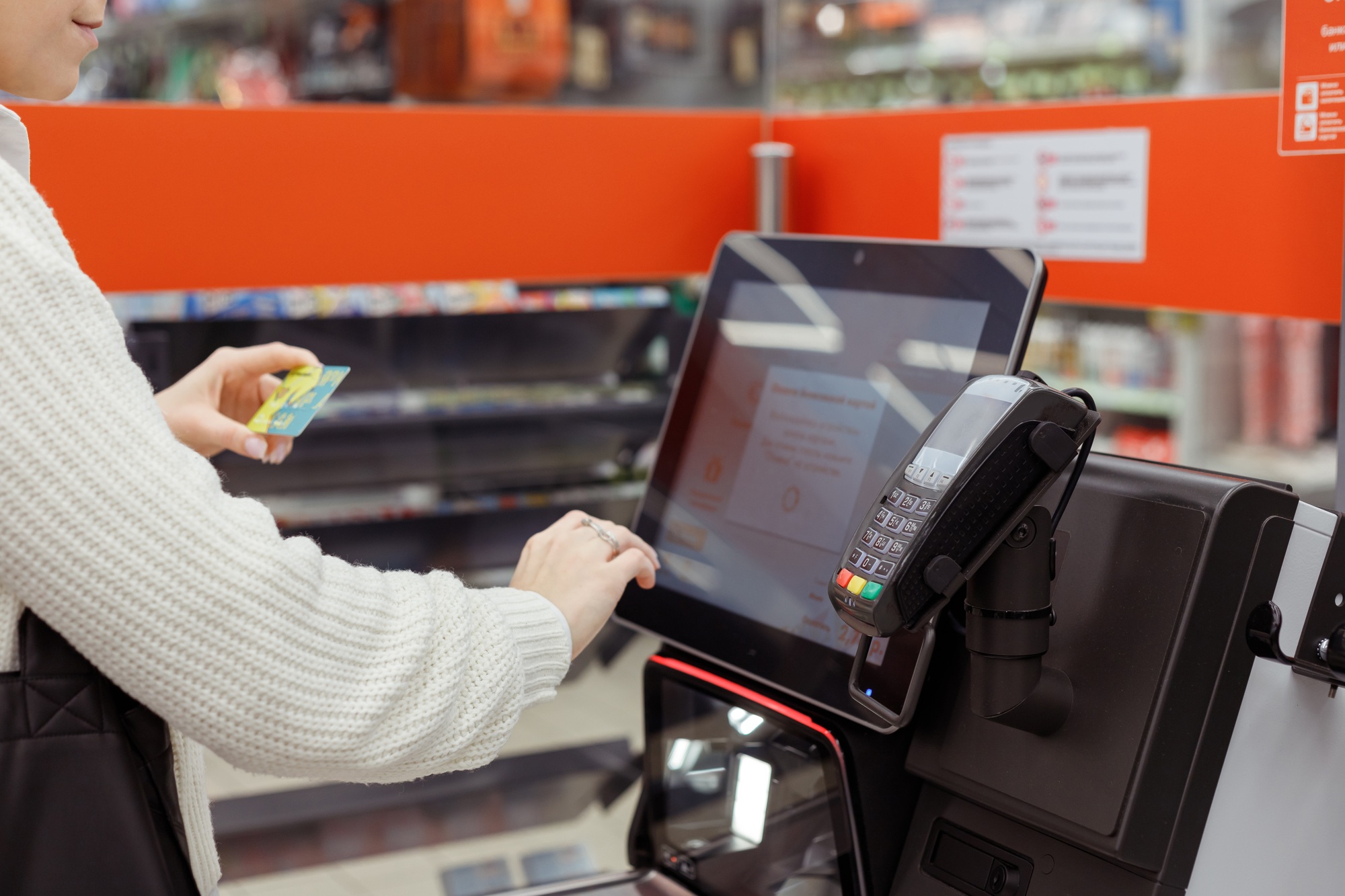 Сustomer woman buys and pays at checkout of self-service vending machine in a modern supermarket