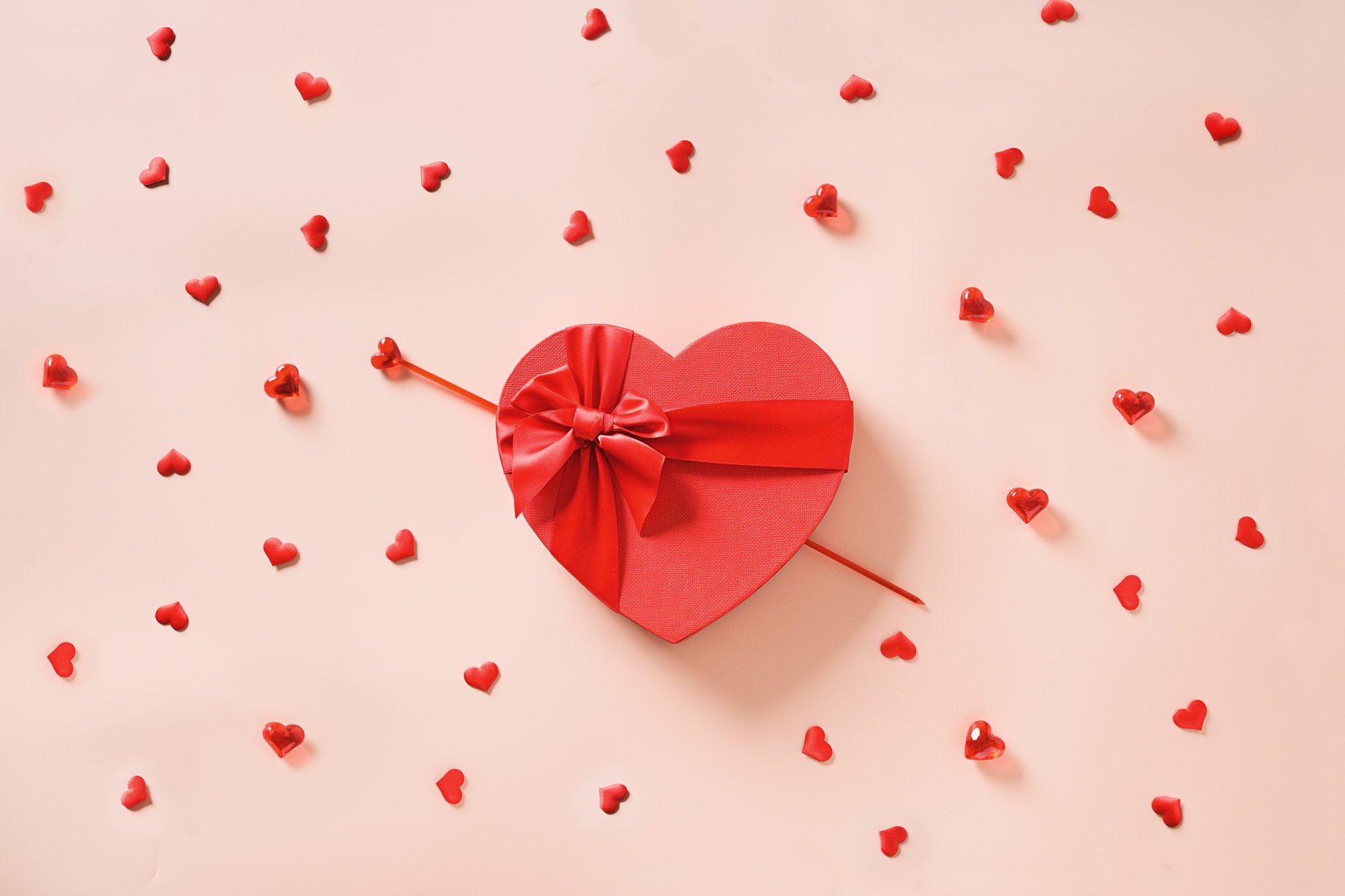 Valentines day heart shaped red gift and many little hearts around.