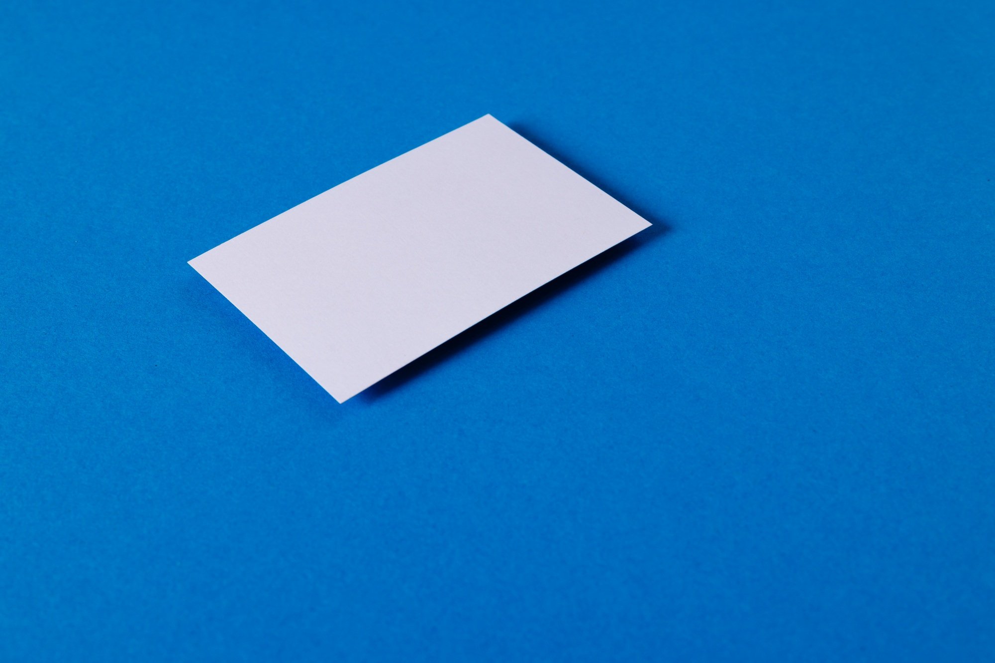 White business card with copy space on blue background