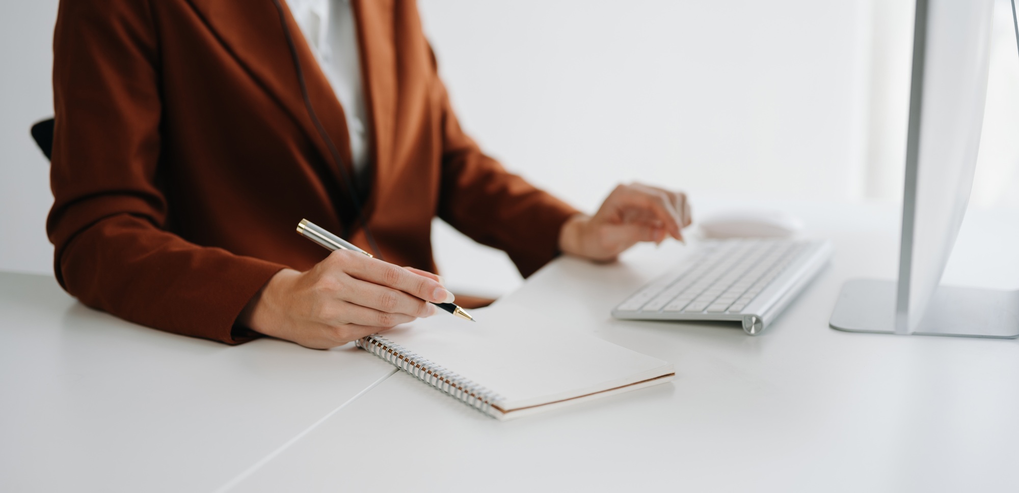 woman hand working with new modern computer and writing on the notepad strategy