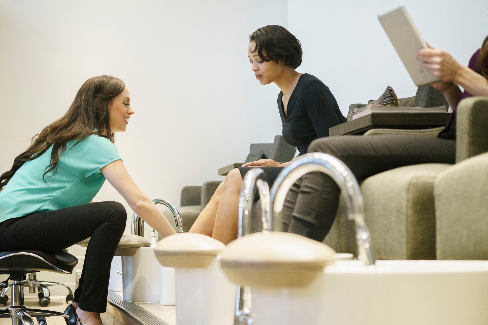Woman having a pedicure with a nail technician in a nail salon.