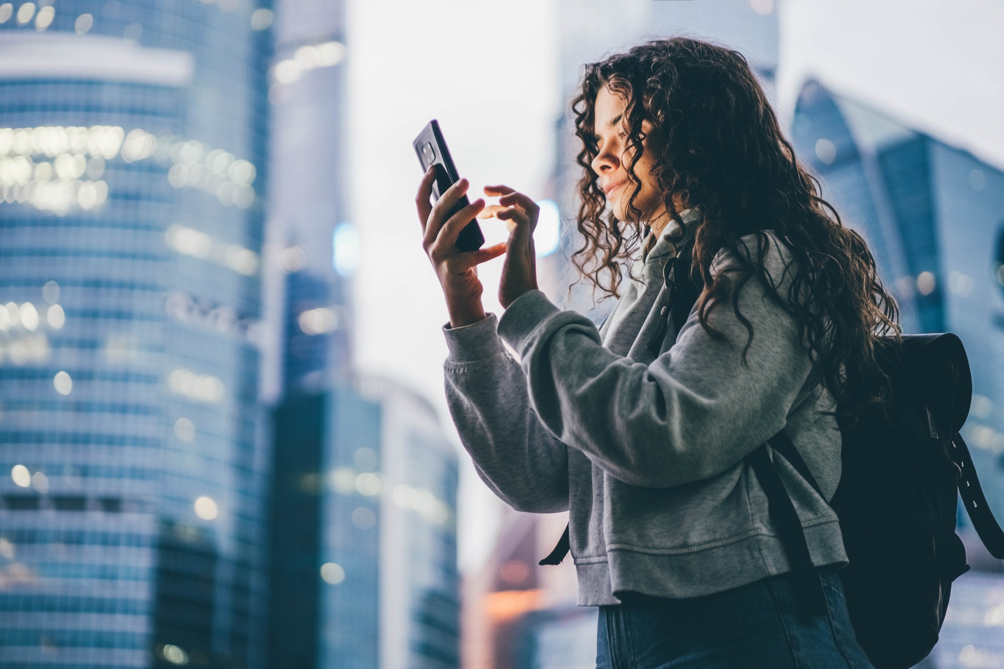 woman holds smartphone and flips through information