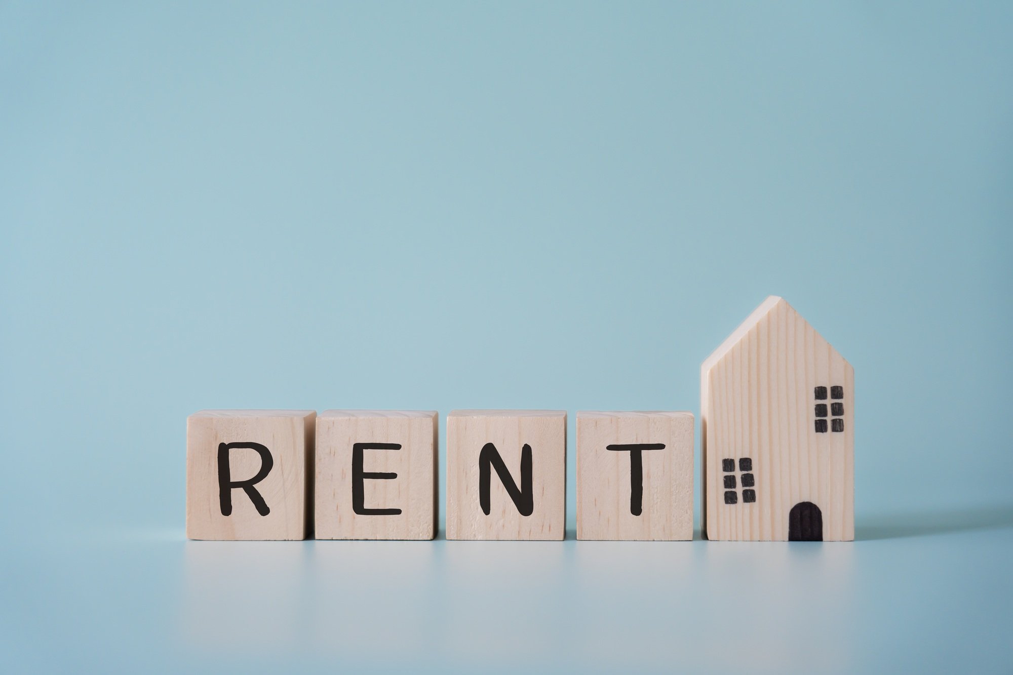 Wooden blocks wording rent and small house model concept of real estate rental