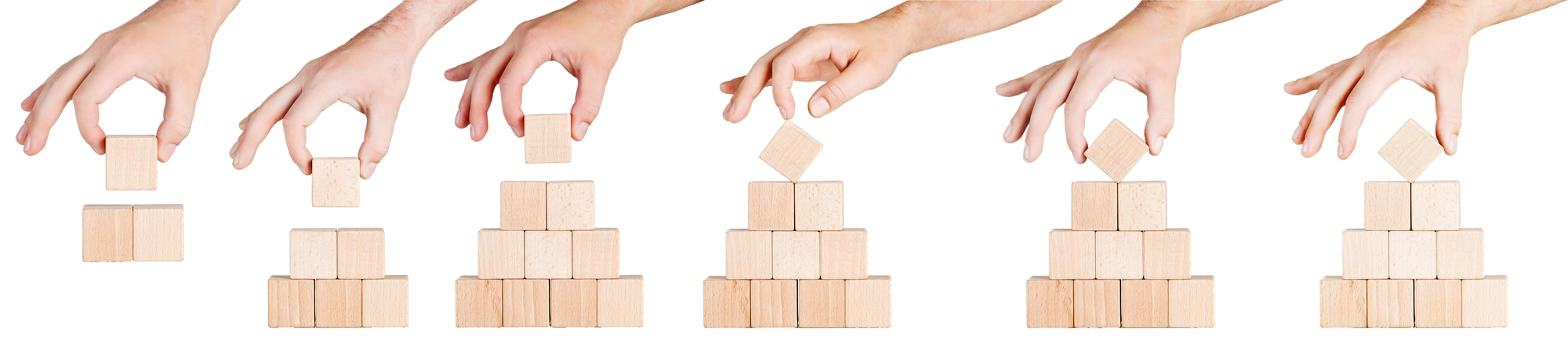wooden cubes in the form of a pyramid with a hand on a white background, isolated background