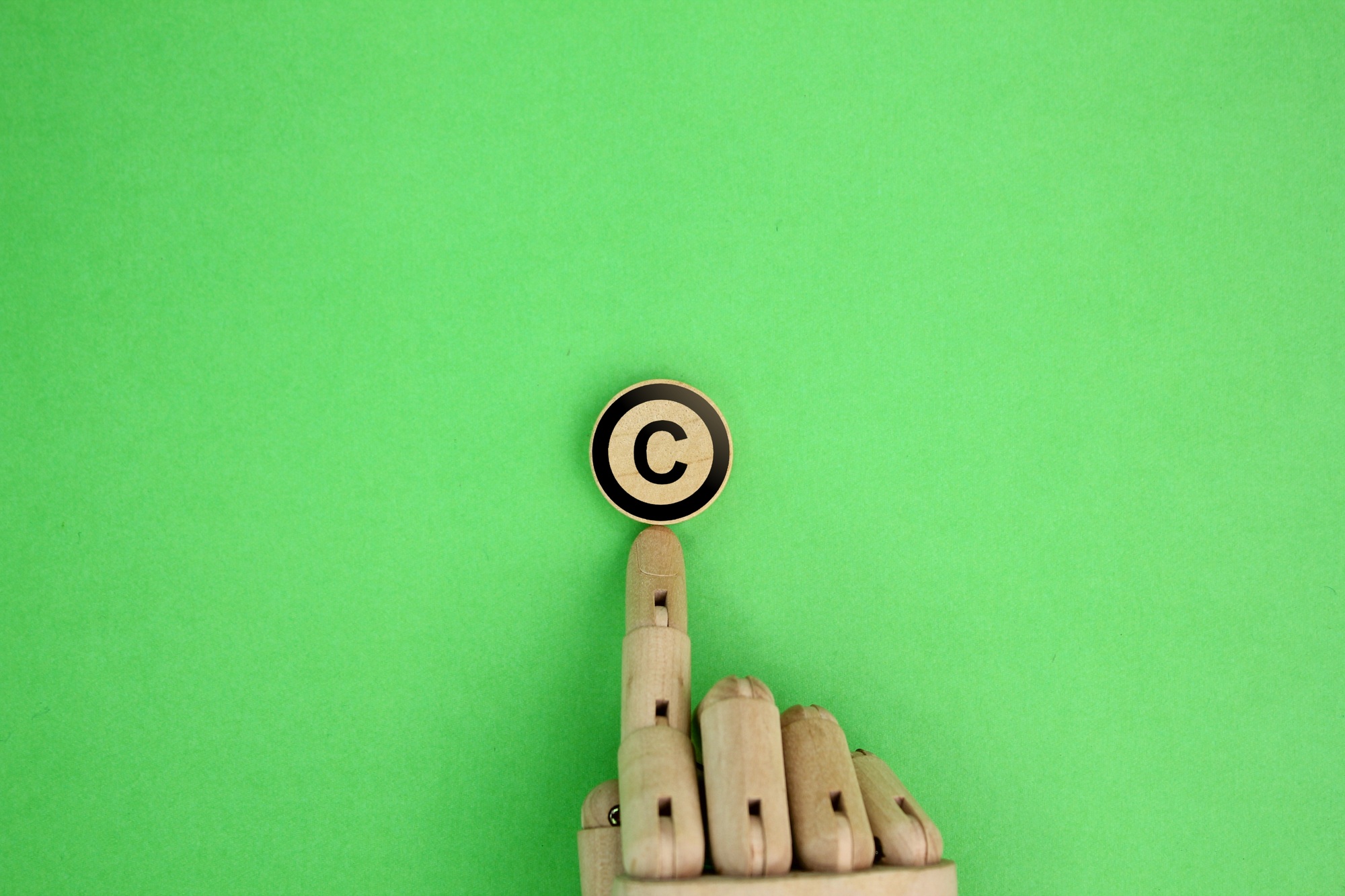 wooden hand and letter C. copyright concept.