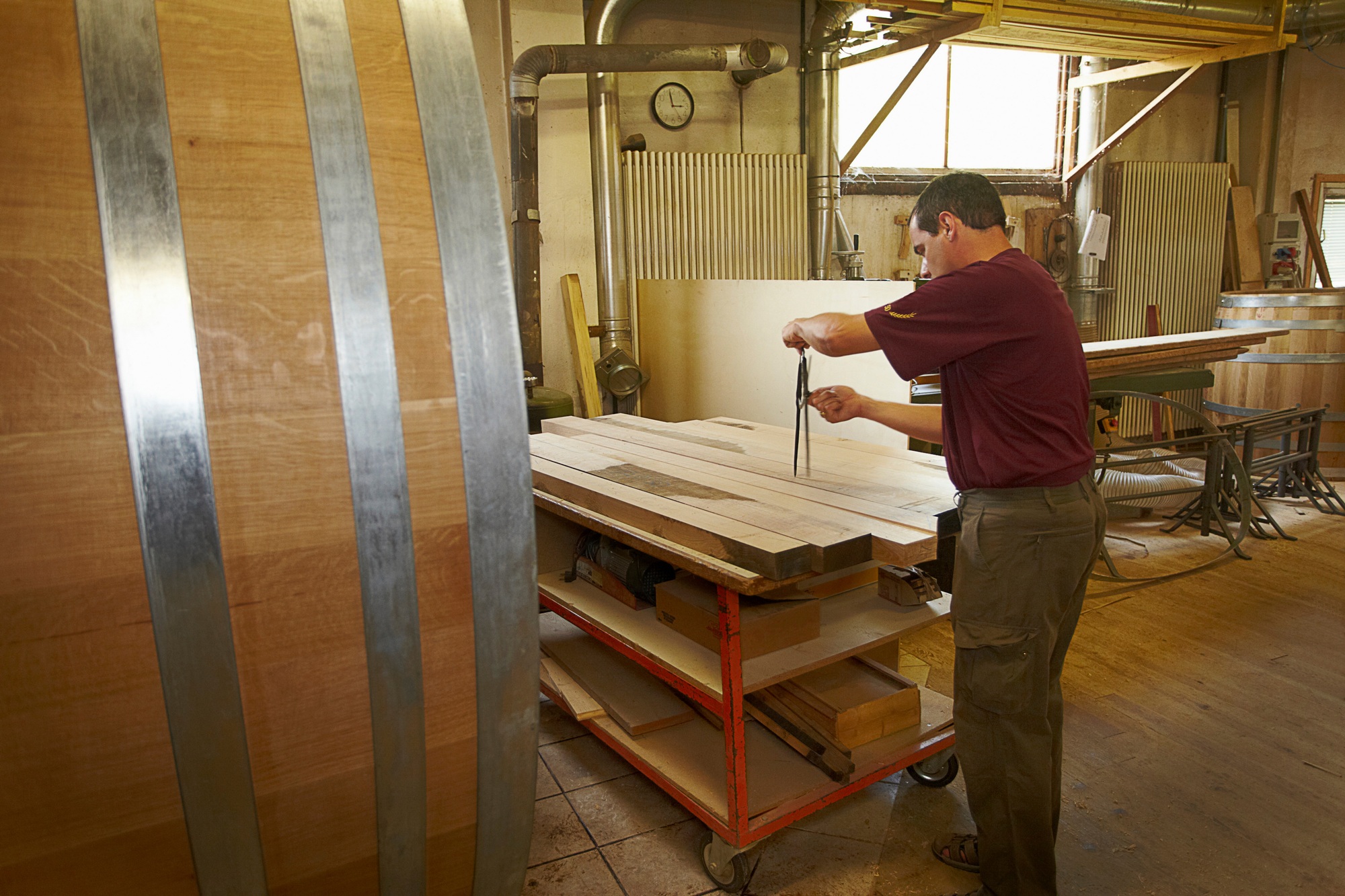 Worker measuring wood in shop
