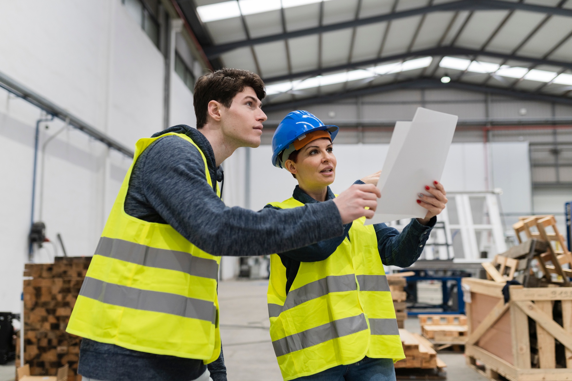 workers of a carpentry shop talking, mature female boss discusses showing plans,