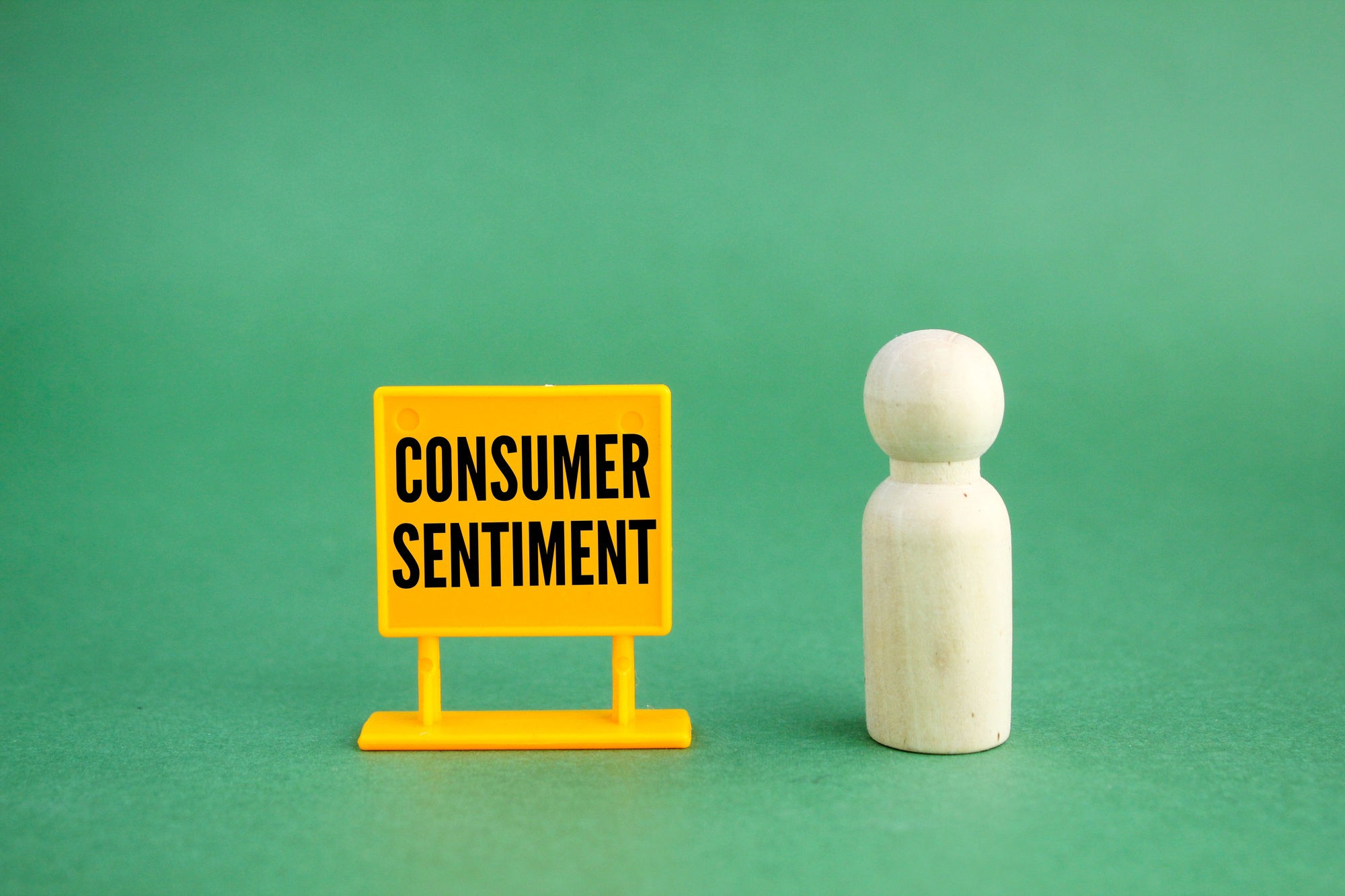 yellow signs and wooden figures with the words Consumer Sentiment