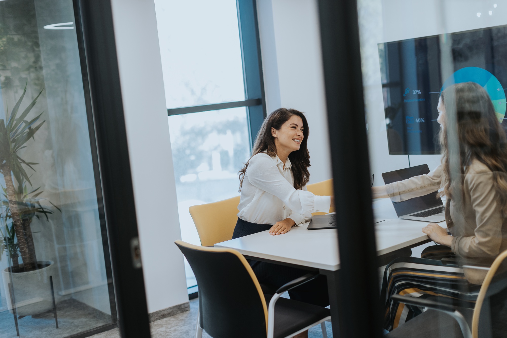 Young business women discussing in cubicle at the office
