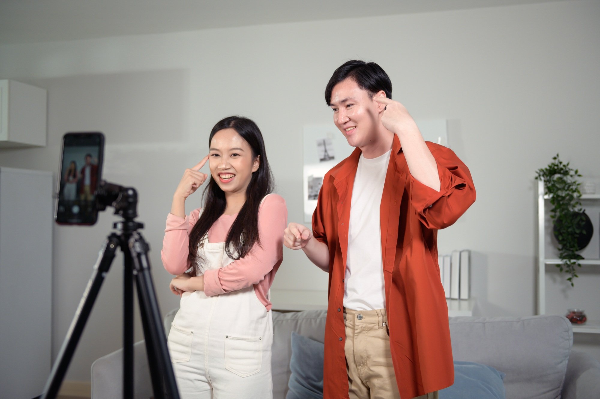 Young couple tiktokers are making video dancing via smartphone