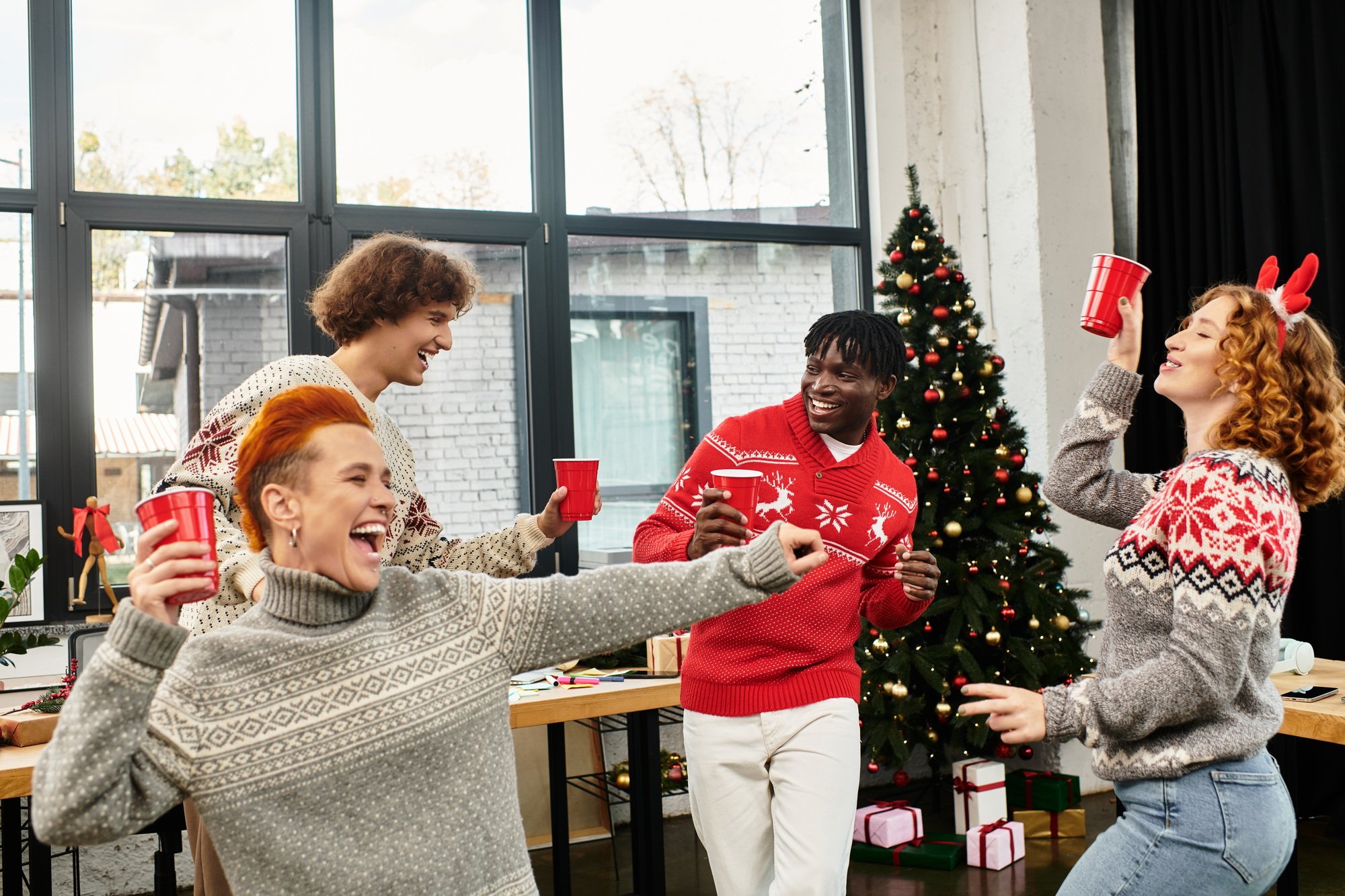 Young coworkers joyfully celebrate Christmas together at the office holiday party in December