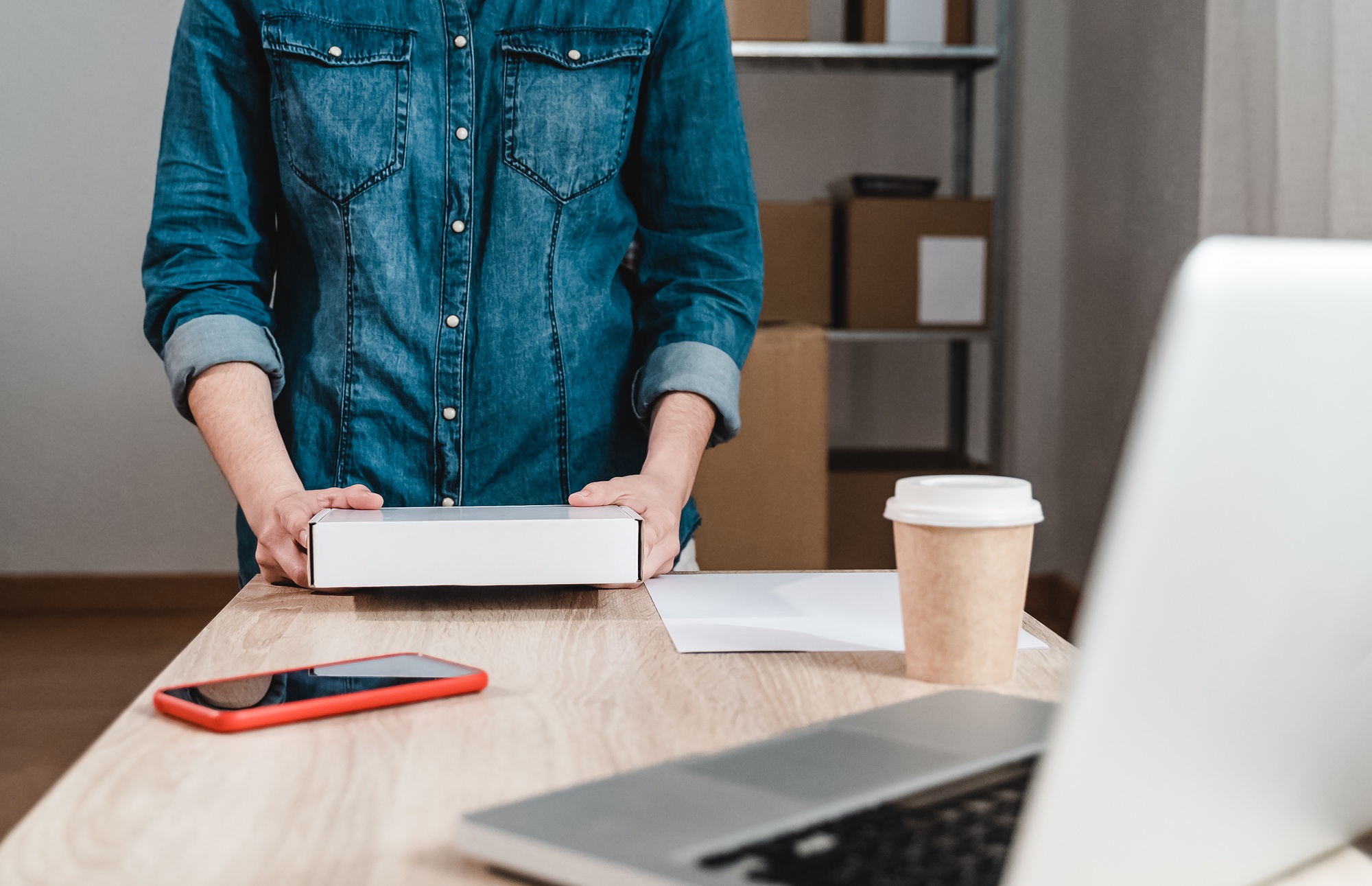 Young female working at warehouse while packing for shipping order - Courier delivery package