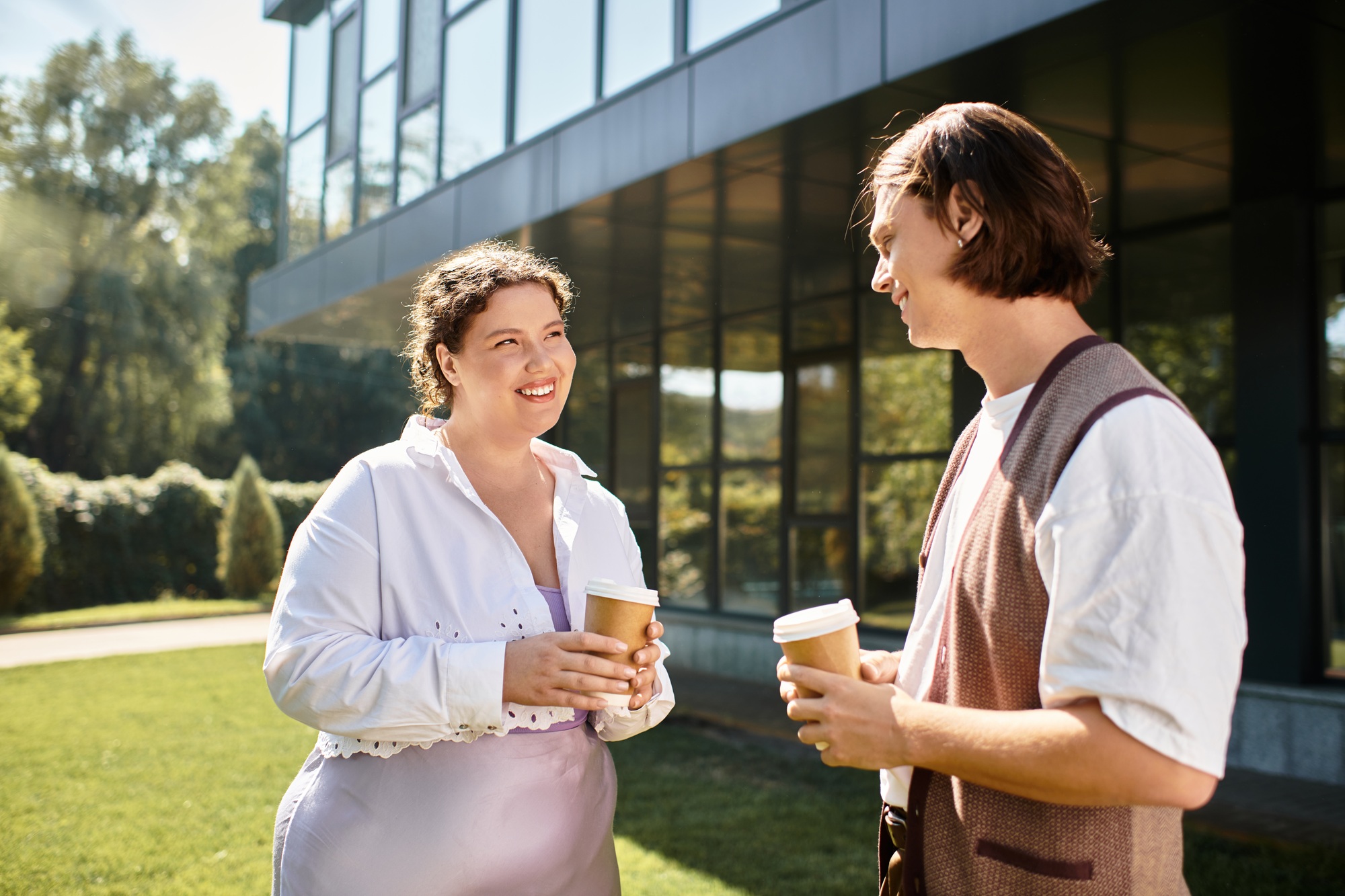 Young plus size woman shares a joyful moment with her male friend over coffee outdoors