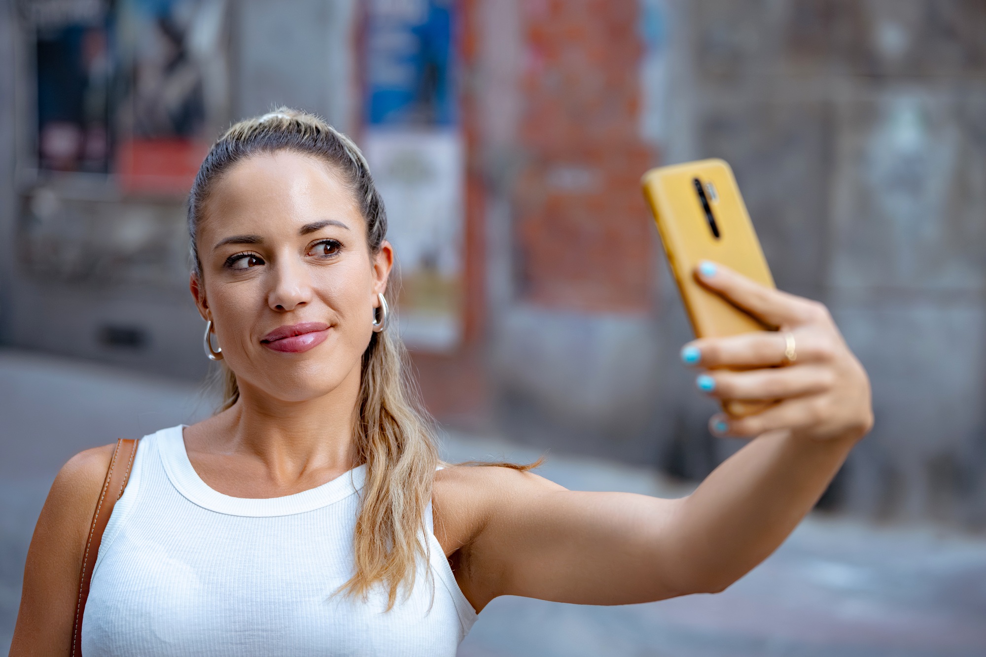 Young woman taking a selfie with smartphone in the city