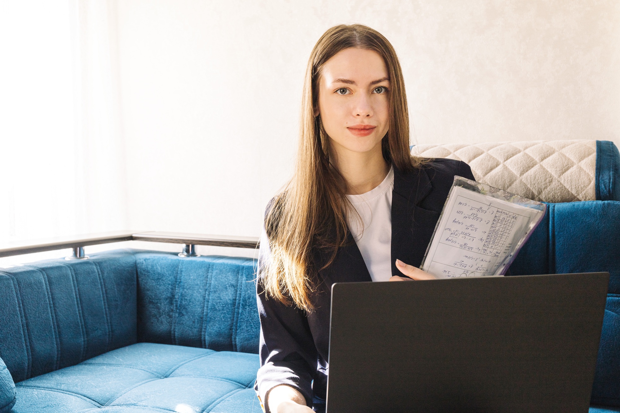 Young woman with a notebook is studying or working at home and working with marketing report.
